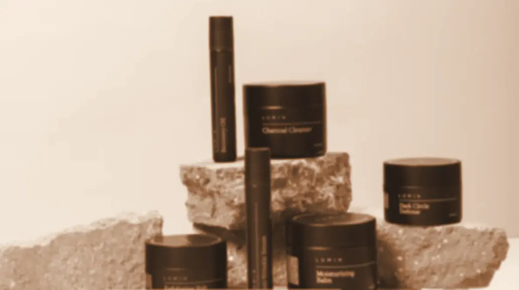Vasetti e flaconi di skincare disposti su blocchi di pietra